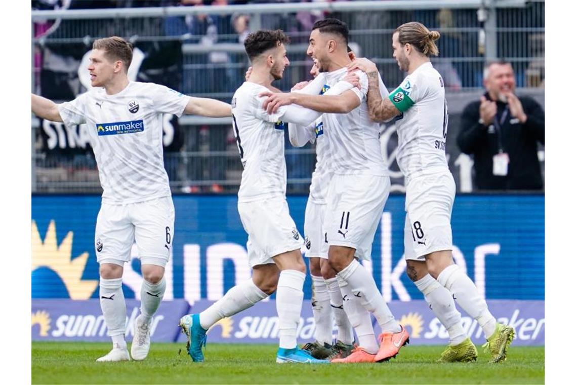 Bielefeld an Tabellenspitze zurück - VfB und HSV patzen Sandhausens Torschütze Aziz Bouhaddouz (2.v.r.) jubelt mit seinen Mannschaftskollegen über das Führungstor gegen Stuttgart. Foto: Uwe Anspach/dpa