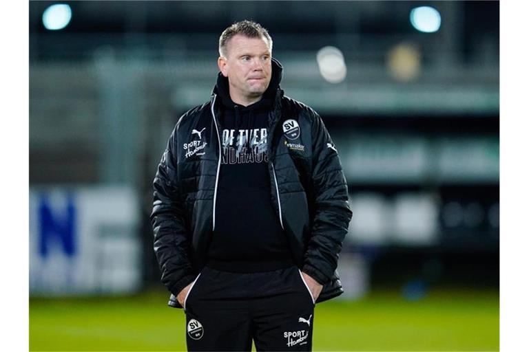 Sandhausens Trainer Uwe Koschinat steht vor dem Spiel im Stadion. Foto: Uwe Anspach/dpa