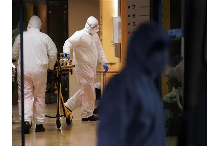 Sanitäter schieben in einem Seniorendomizil im Stadtteil Lichtenberg eine Tragbahre. Foto: Jörg Carstensen/dpa