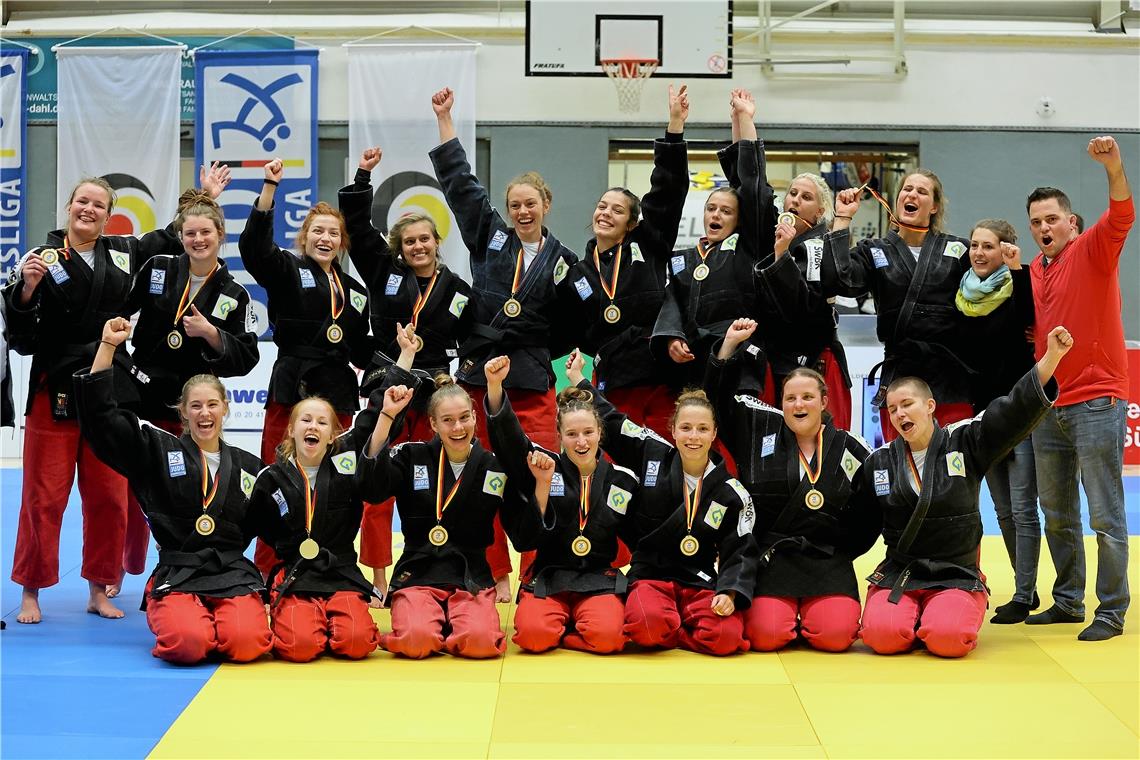 Sanne van Dijke, Malin Fischer, Lubjana Piovesana, Julia Mollet, Sarah Mäkelburg, Alina Böhm, Raffaela Igl, Anamari Velensek, Anna-Maria Wagner, Physiotherapeutin Stephanie Holderle, Trainer Jens Holderle (hinten von links), Sarah Mehlau, Nikita Krieger, Viktoria Folger, Chiara Serra, Amelie Stoll, Tanja Hehr, Jasmin Delorme (vorne) jubeln über Gold. Foto: F. Hoffmann