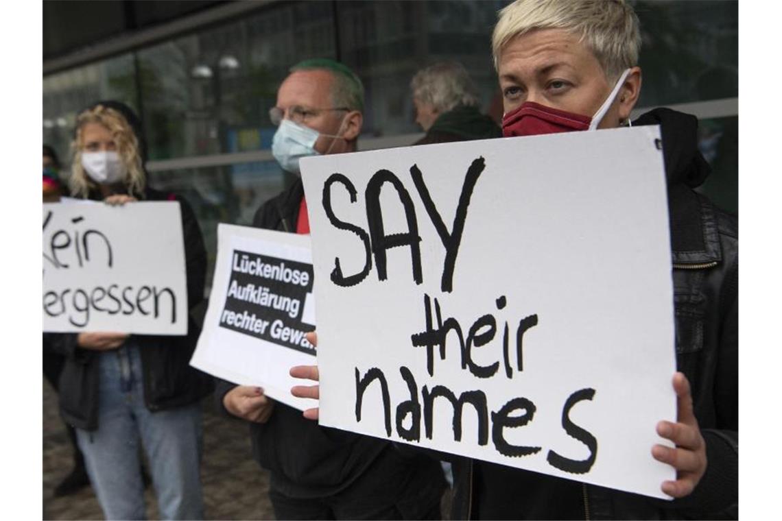 „Say their names“ („Nennt ihre Namen“) steht auf einem Schild, mit dem eine Demonstrantin vor dem Gericht an die Opfer rechter Gewalt erinnert. Foto: Boris Roessler/dpa