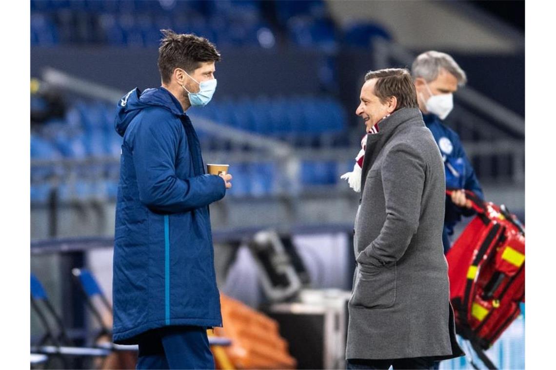 Schalke-Neuzugang Klaas-Jan Huntelaar (l) unterhält sich vor der Partie mit Kölns Sportdirektor Horst Heldt. Foto: Marius Becker/dpa