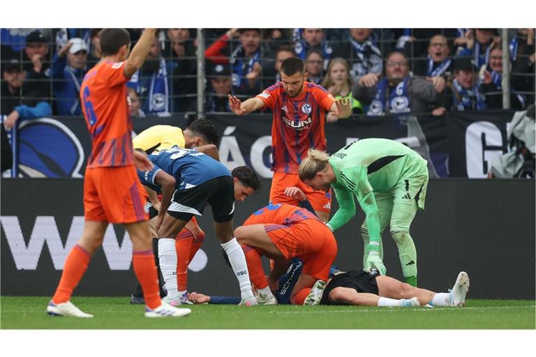 Schalke-Profi Nikola Katic hilft seinem am Boden liegenden Gegenspieler Joel Grodowski sofort.