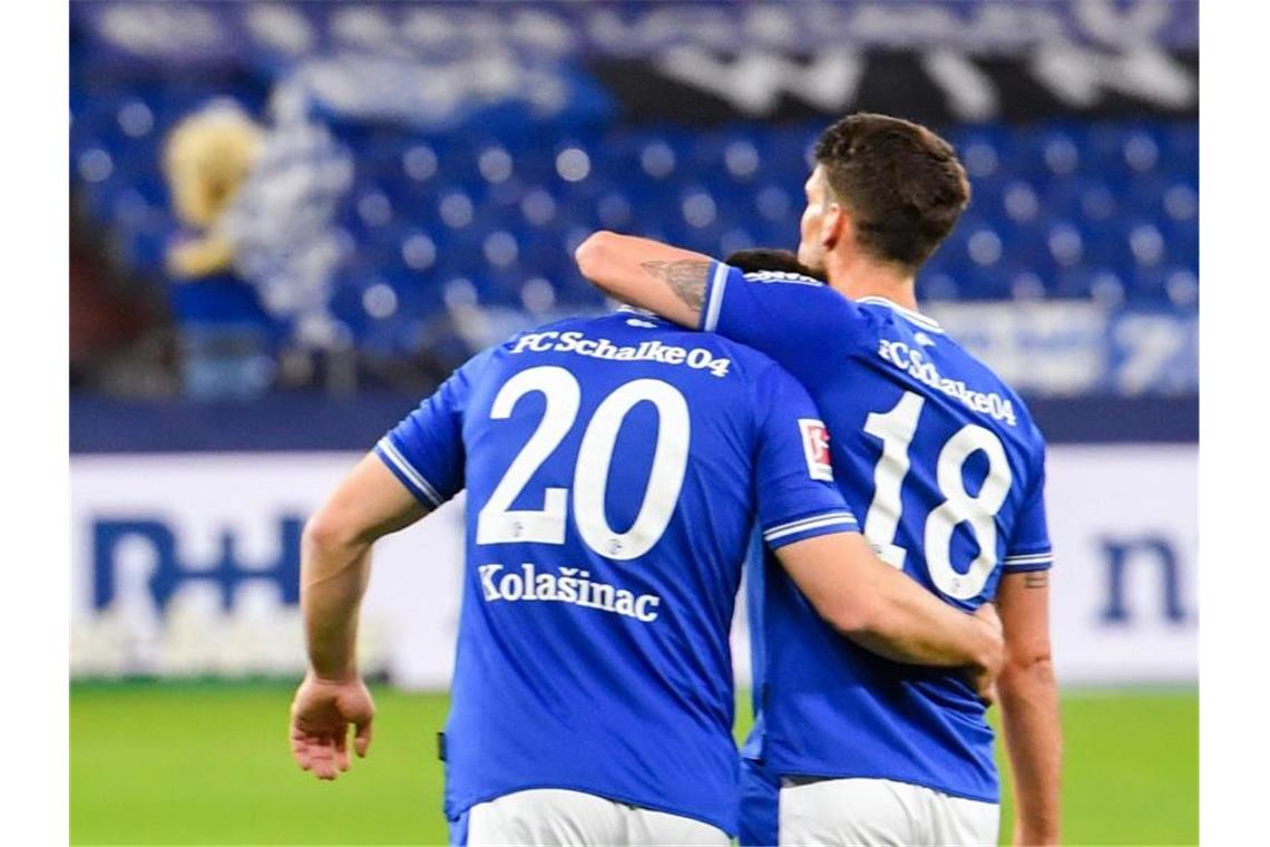 Schalkes Abwehrspieler Sead Kolasniac und Schalkes Stürmer Goncalo Paciencia freuen sich über den Sieg. Foto: Bernd Thissen/dpa