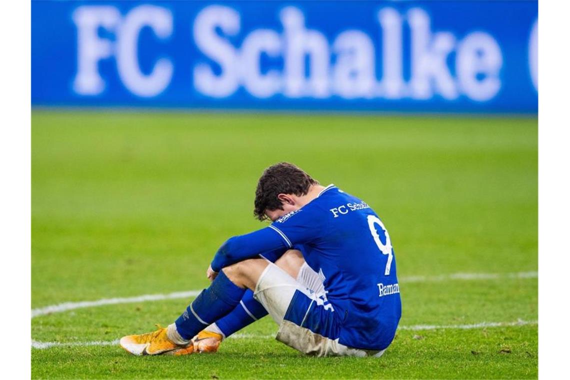 Schalkes Benito Raman sitzt nach dem Abpfiff auf dem Rasen. Foto: Guido Kirchner/dpa
