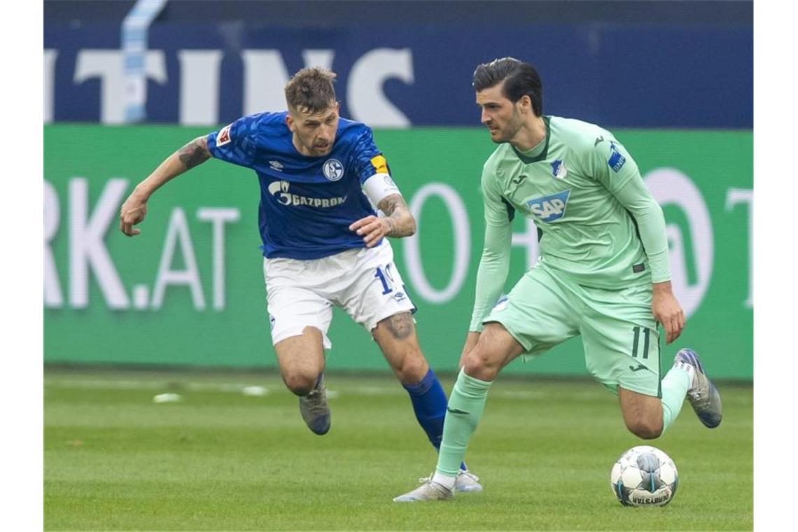 Schalkes Guido Burgstaller und Hoffenheims Florian Grillitsch (l-r.) im Zweikampf um den Ball. Foto: David Inderlied/dpa