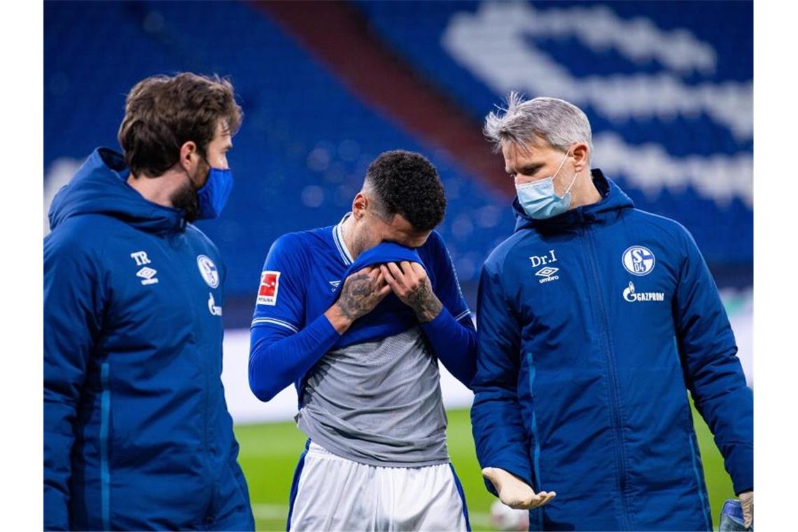 Schalkes Omar Mascarell (m) geht verletzungsbedingt vom Platz. Foto: Guido Kirchner/dpa