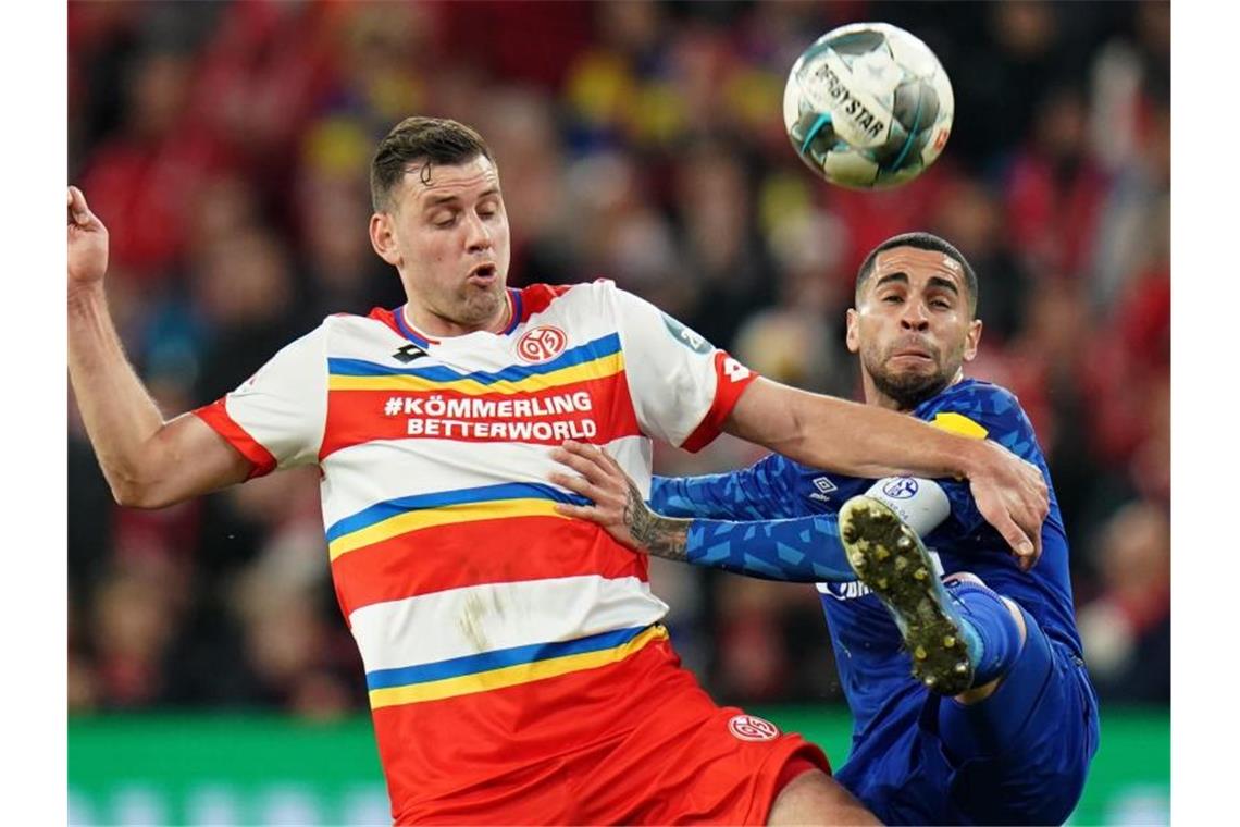 Schalkes Omar Mascarell (r) und der Mainzer Adam Szalai kämpfen um den Ball. Foto: Thomas Frey/dpa