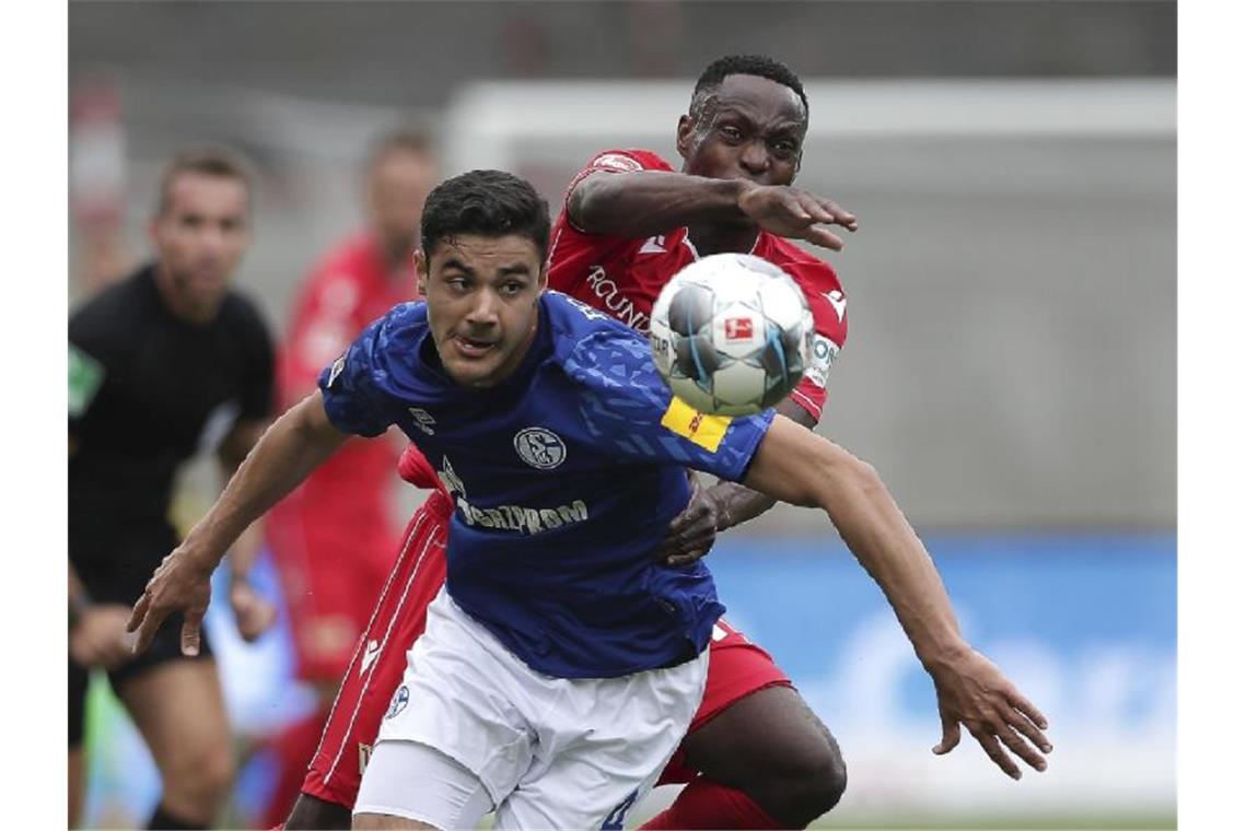Schalkes Ozan Kabak im Duell mit Unions Anthony Ujah (r). Foto: Michael Sohn/AP POOL/dpa