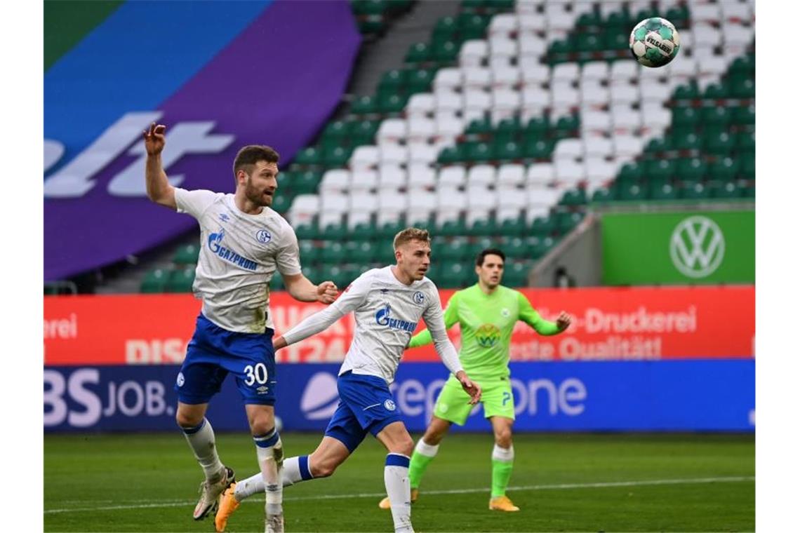 FC Bayern legt vor - Klatsche für Schalke 04 Schalkes Shkodran Mustafi (l) köpft den Ball zur Wolfsburger Führung ins eigene Tor. Foto: Swen Pförtner/dpa