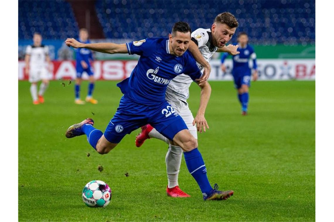 Stevens geht mit Sieg bei Schalke Schalkes Steven Skrzybski (l) und Ulms Albano Gashi kämpfen um den Ball. Foto: Guido Kirchner/dpa