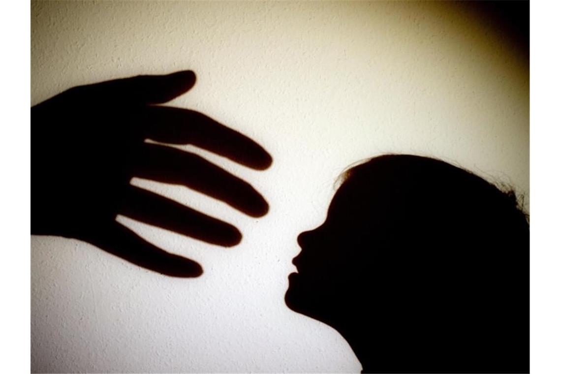 Schatten einer Hand einer erwachsenen Person neben dem Schatten eines Kindes. Foto: Patrick Pleul/dpa-Zentralbild/dpa/Illustration