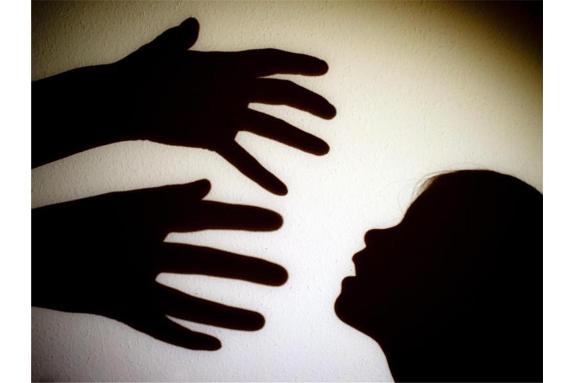 Schatten von Händen eines Erwachsenen und dem Kopf eines Kindes sind an einer Wand zu sehen. Foto: Patrick Pleul/zb/dpa/Archivbild