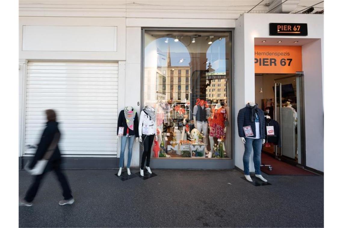 Schaufensterpuppen eines Kleidungsgeschäftes stehen vor einem geöffneten Laden in Hamburg. Foto: Daniel Reinhardt/dpa