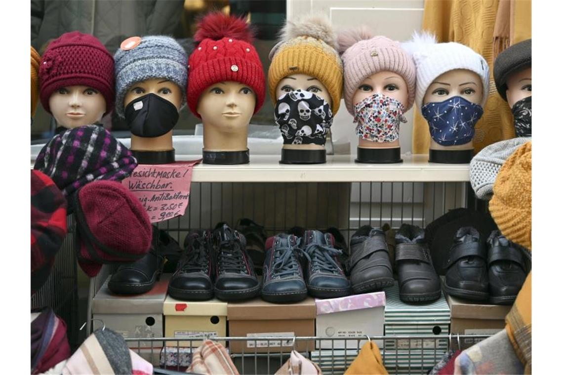 Studie: Fast jeder Dritte ist ein Modemuffel Schaufensterpuppenköpfe mit Gesichtsmasken, Tüchern und Mützen stehen vor einem Bekleidungsgeschäft in der Altstadt von Mühlhausen. Foto: Martin Schutt/dpa-Zentralbild/dpa