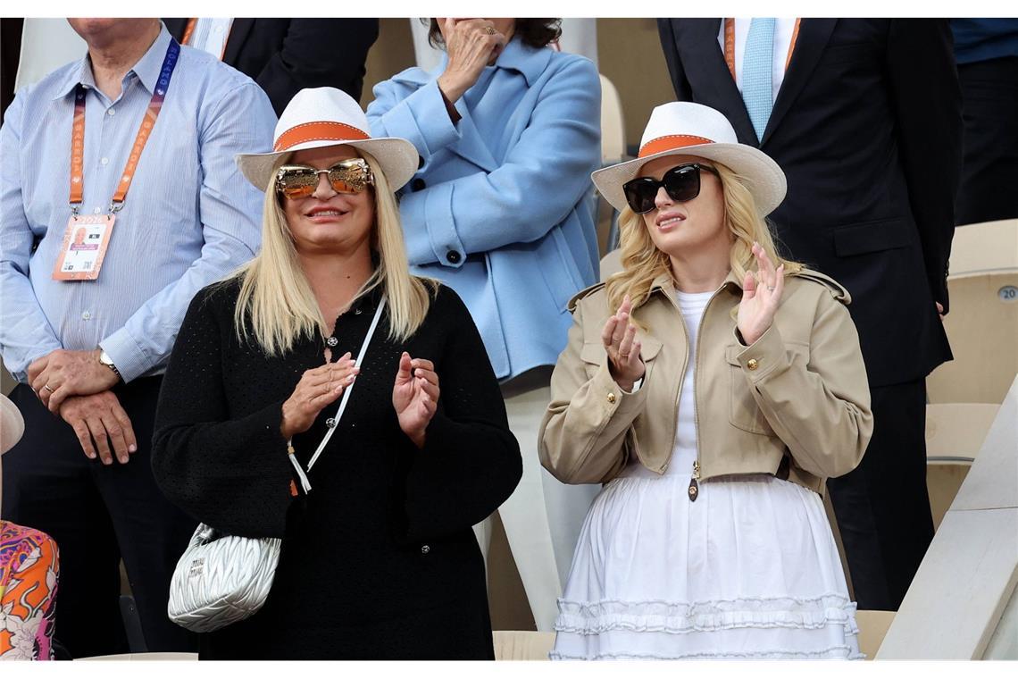 Schauspielerin Rebel Wilson (r.) und eine Begleitung applaudieren während des Endspiels auf der Tribüne.