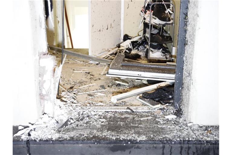 Scherben liegen in einem Gebäudeeingang in Duisburg, nachdem Einsatzkräfte bei einer Razzia die Tür aufgesprengt haben. Foto: Justin Brosch/dpa