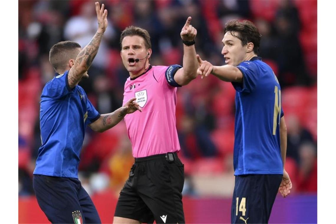 Schiedsrichter Felix Brych im Zwiegespräch mit den beiden Italienern Marco Verratti (l) und Federico Chiesa. Foto: Laurence Griffiths/Pool Getty/AP/dpa