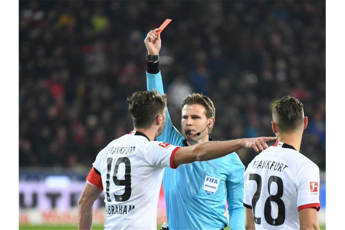 Schiedsrichter Felix Brych zeigt David Abraham nach einem Foul an Trainer Streich die rote Karte. Foto: Patrick Seeger/dpa/Archivbild