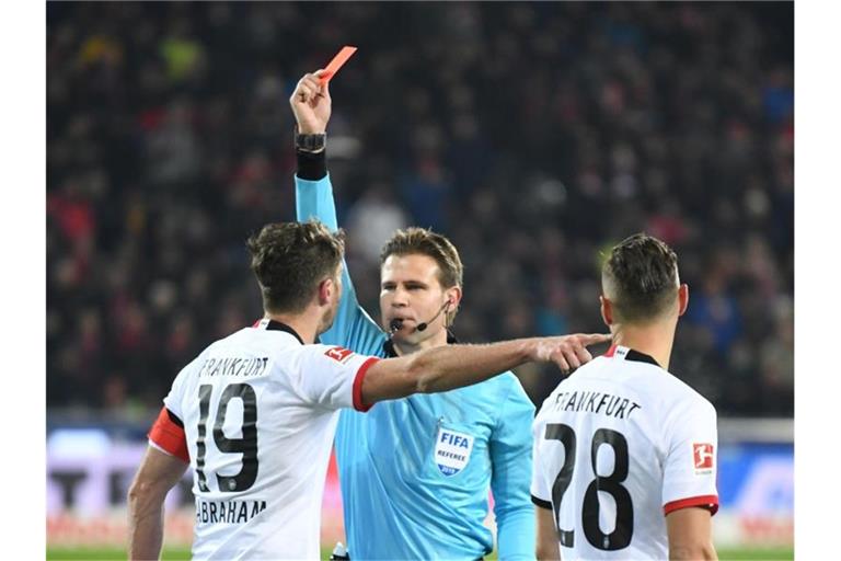 Schiedsrichter Felix Brych zeigt David Abraham nach einem Foul an Freiburgs Trainer die rote Karte. Foto: Patrick Seeger/dpa/Archivbild