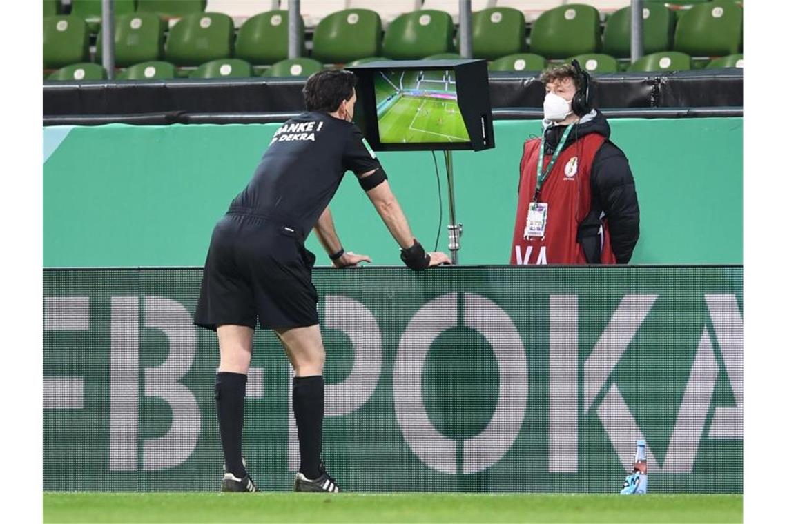 Schiedsrichter Manuel Gräfe nimmt den Videobeweis zu Hilfe und nimmt einen gegebenen Elfmeter zurück. Foto: Carmen Jaspersen/dpa
