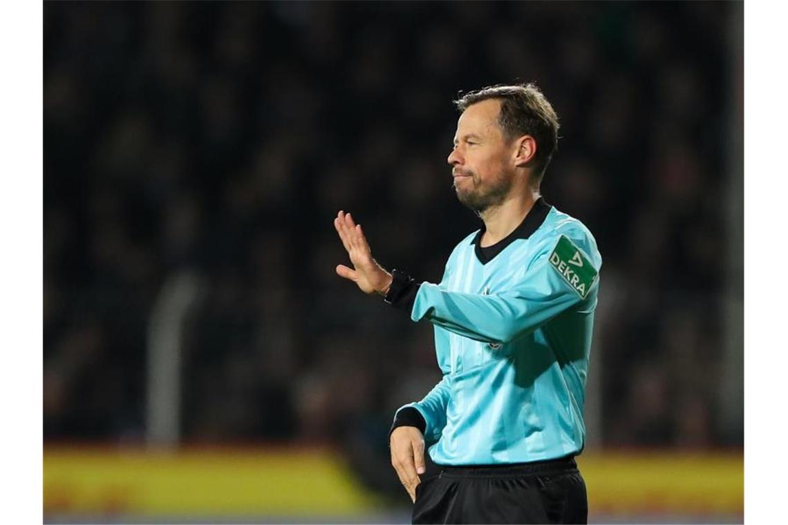 Schiedsrichter Markus Schmidt gibt ein Handzeichen. Foto: Friso Gentsch/dpa/Archivbild