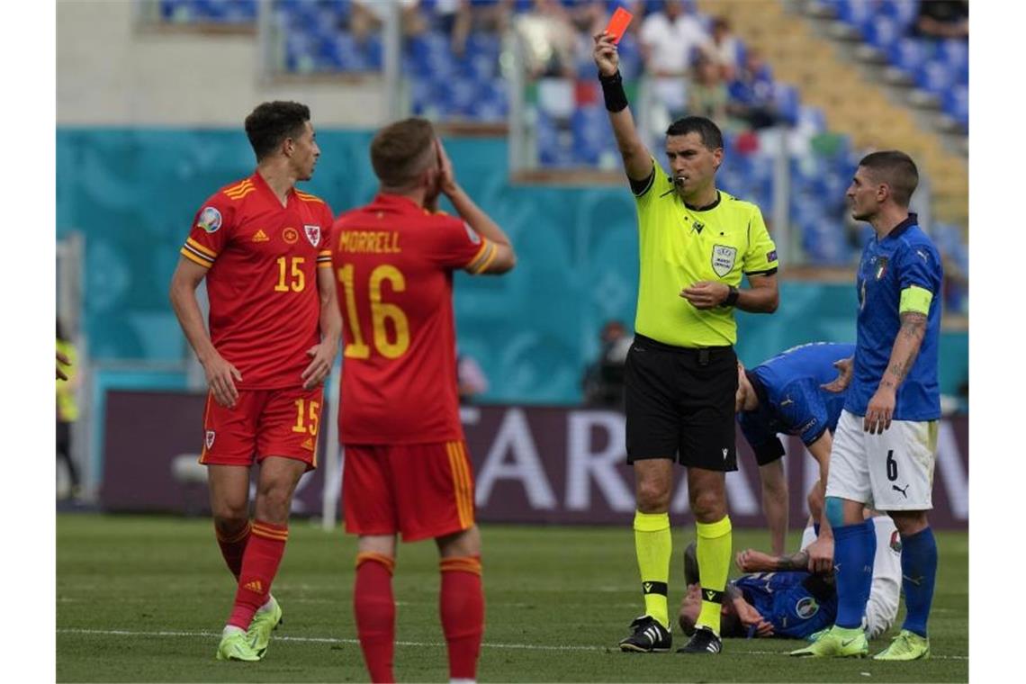 Schiedsrichter Ovidiu Haţegan zeigt Ethan Ampadu (16) von Wales die Rote Karte. Foto: Alessandra Tarantino/AP Pool/dpa