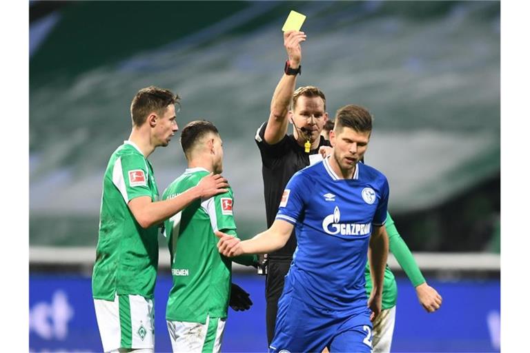 Schiedsrichter Sören Starke zeigt dem Schalker Klaas-Jan Huntelaar nach einem Foul die Gelbe Karte. Foto: Carmen Jaspersen/dpa