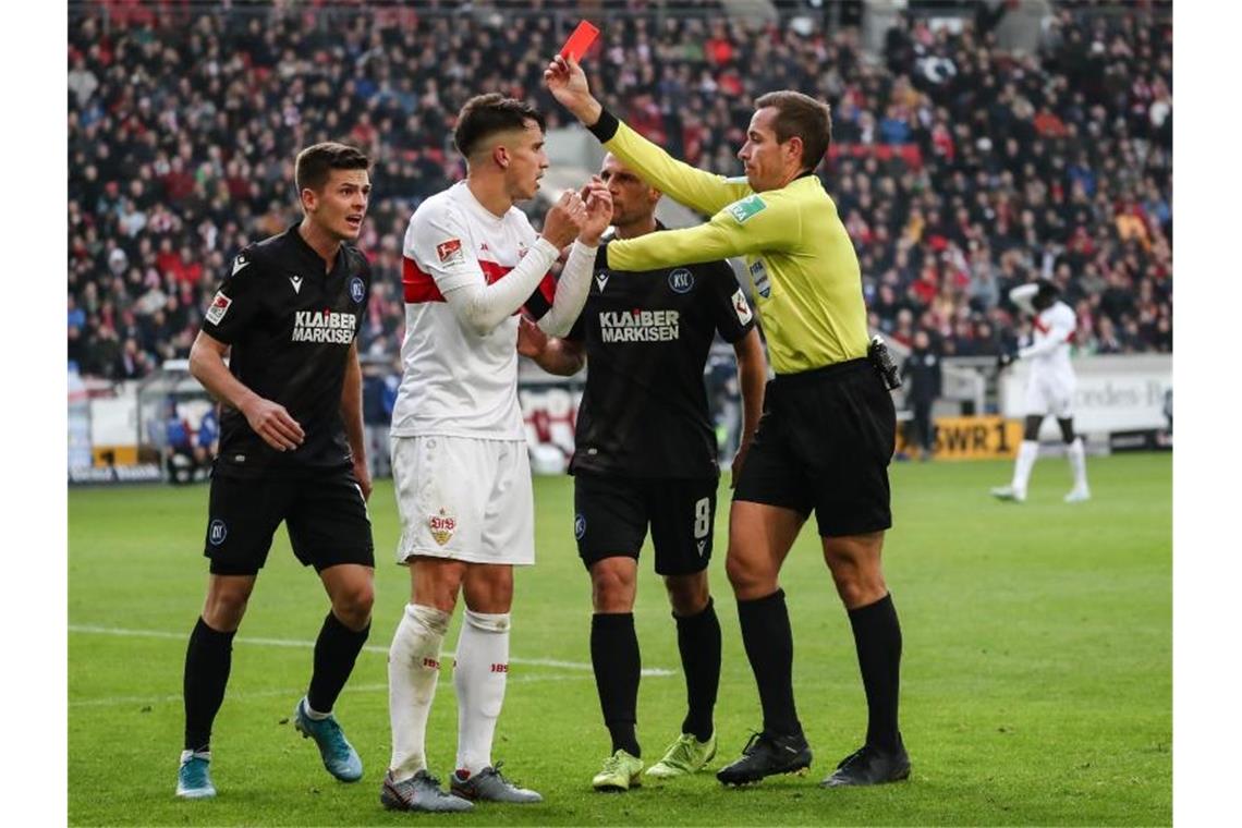 Schiedsrichter Stieler (r) zeigt VfB-Kapitän Kempf (2.v.l) nach einem Foulspiel die Rote Karte. Foto: Christoph Schmidt/dpa