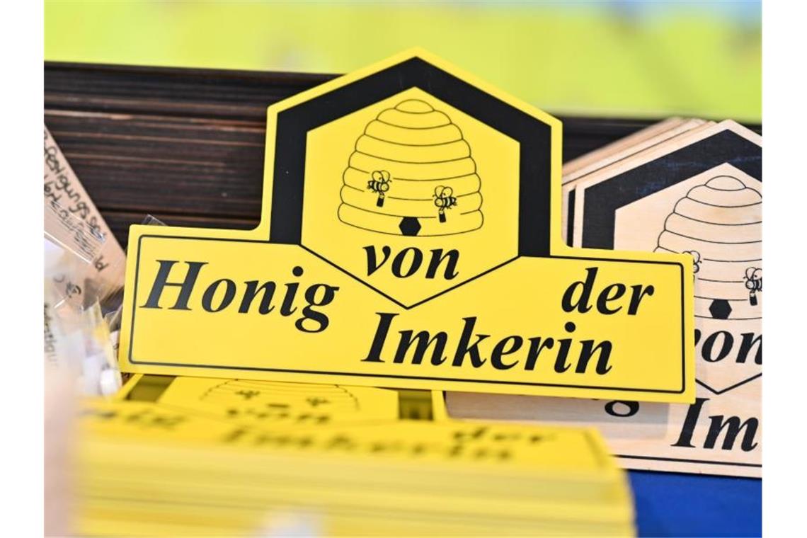 Schilder mit der Aufschrift „Honig von der Imkerin“. Foto: Felix Kästle/dpa/Archivbild