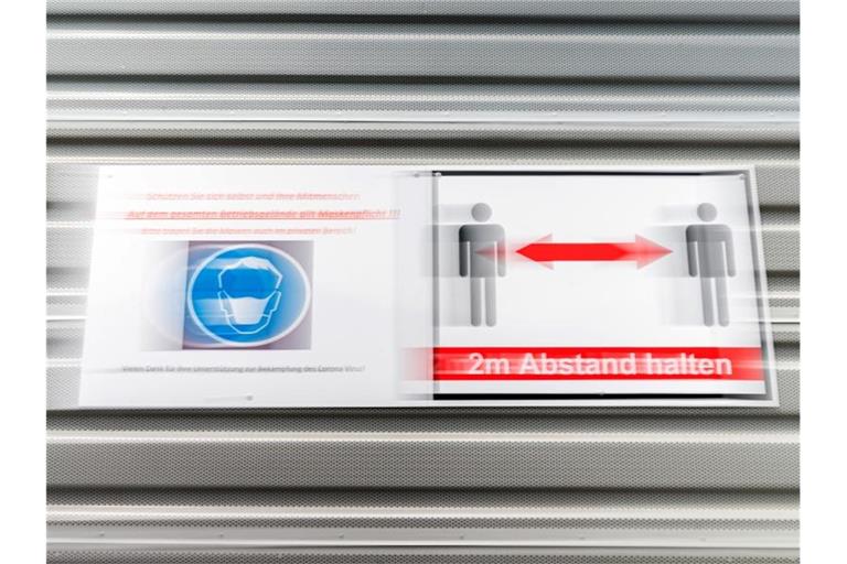 Schilder weisen auf Maskenpflicht und Mindestabstand hin. Foto: Mohssen Assanimoghaddam/dpa/Archivbild
