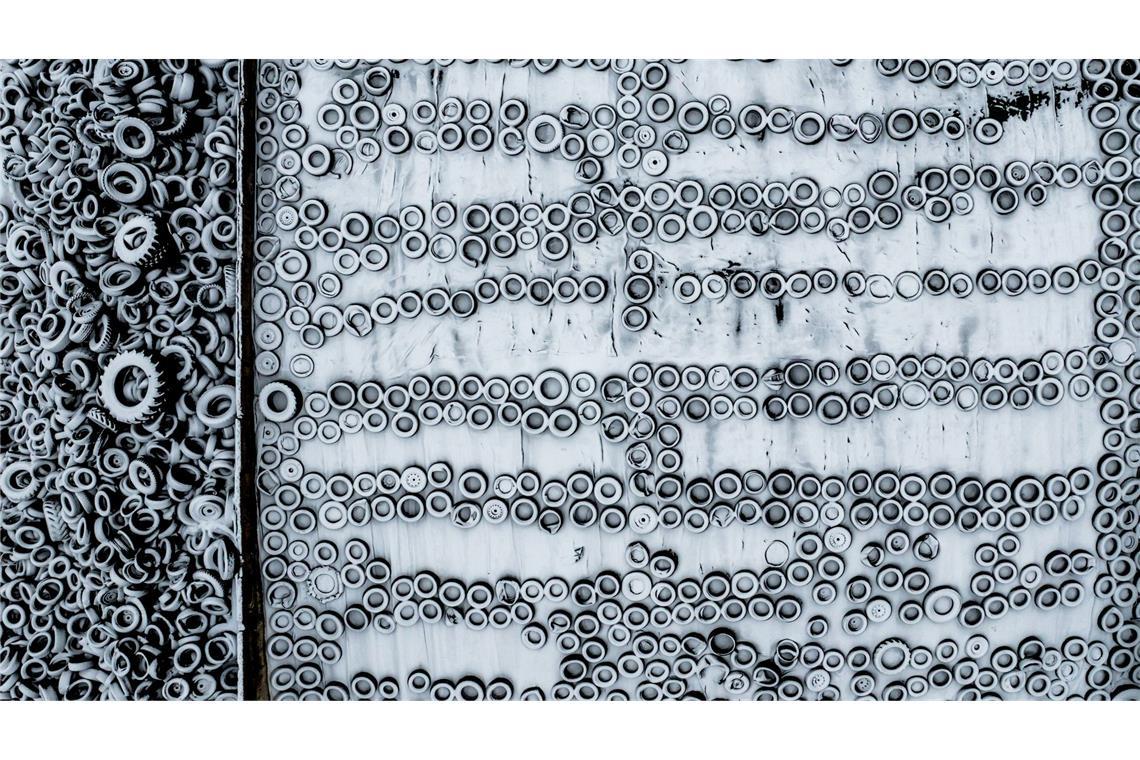 Schnee bedeckt ein Futtersilo, auf dem ausgediente Autoreifen die Schutzfolie beschweren.