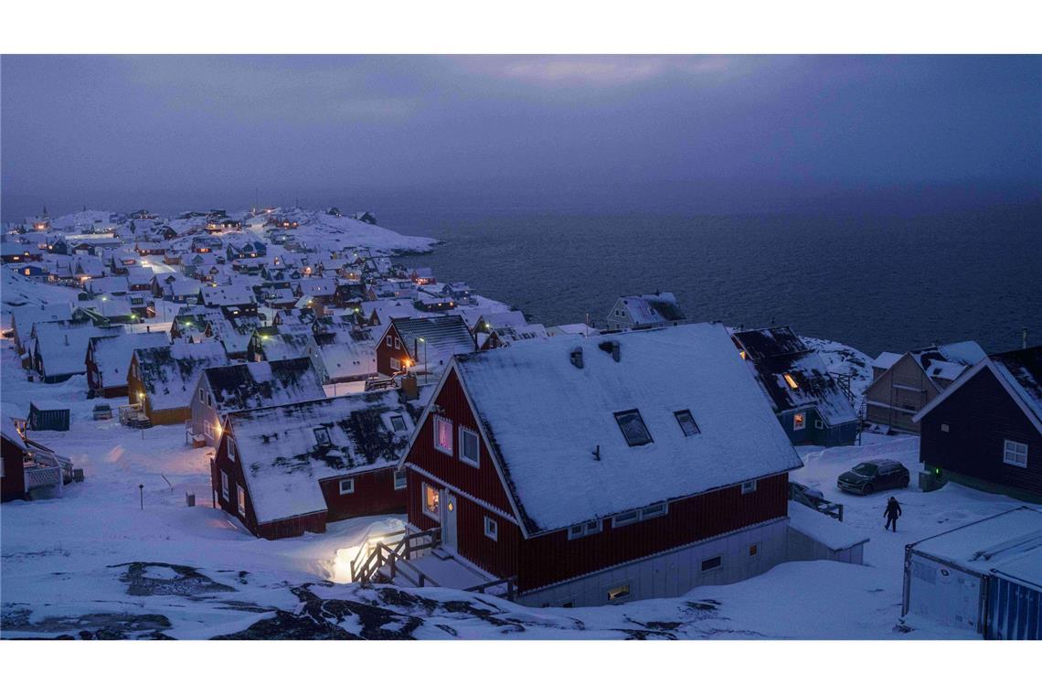Schnee bedeckte Häuser stehen an der Küste einer Meeresbucht in Nuuk, der Hauptstadt von Grönland.