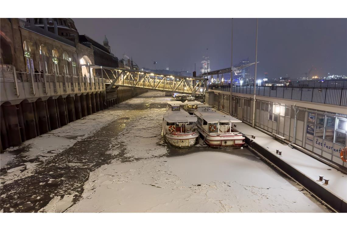 Schnee und Eis ist am späten Abend auf dem Wasser der Elbe in Hamburg zu sehen.