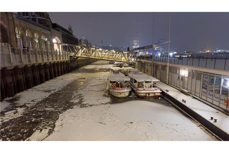 Schnee und Eis ist am späten Abend auf dem Wasser der Elbe in Hamburg zu sehen.