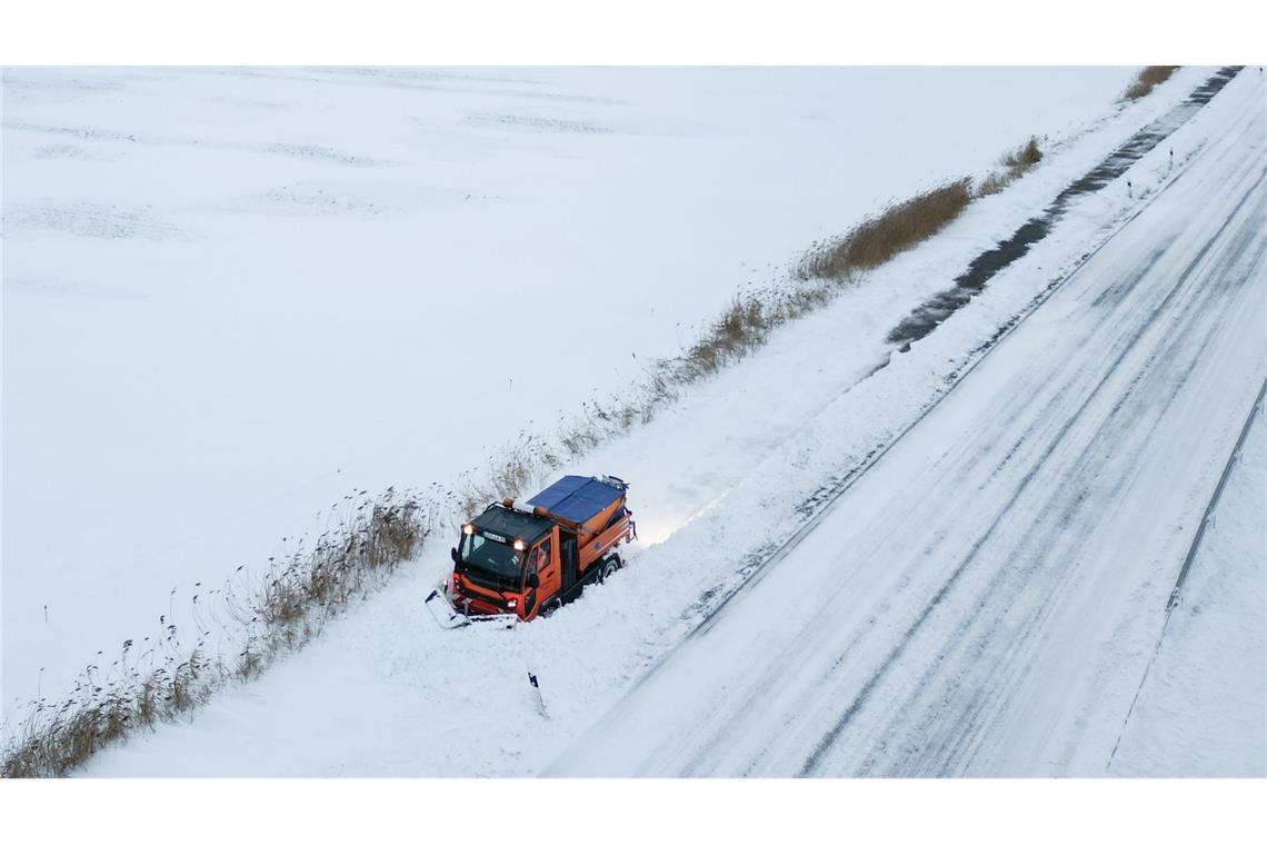 Schneepflug kämpft gegen Verwehungen auf Gehweg bei Bingum