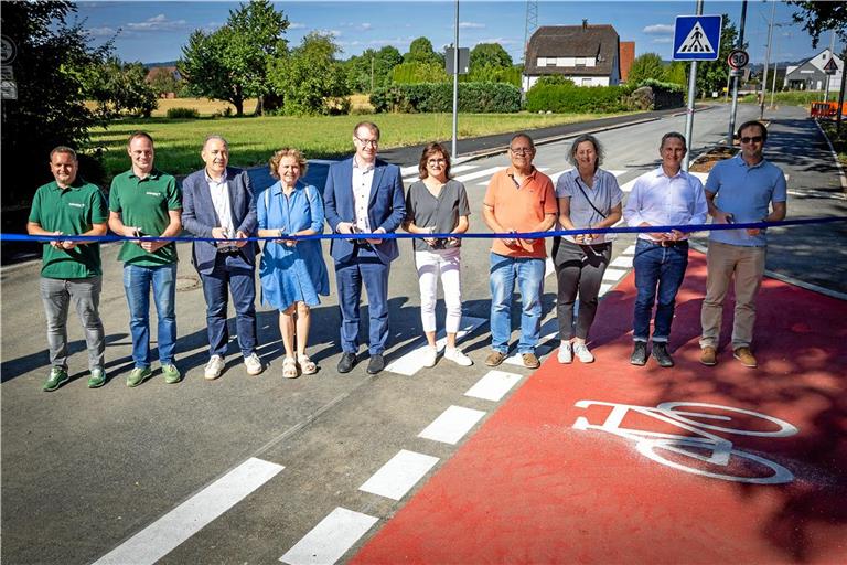 Schneiden das Eröffnungsband durch (von links): Davis Unrath und Jonas Zehnder von der Firma Zehnder, Erster Bürgermeister Stefan Setzer, Regina Konrad, Maximilian Friedrich, Natascha Bobleter, der ehemalige Ortschaftsrat Peter Tenschert, Susanne Wenzel (Büro Frank), Lars Kaltenleitner und Jürgen Denzer vom Tiefbauamt. Foto: Alexander Becher