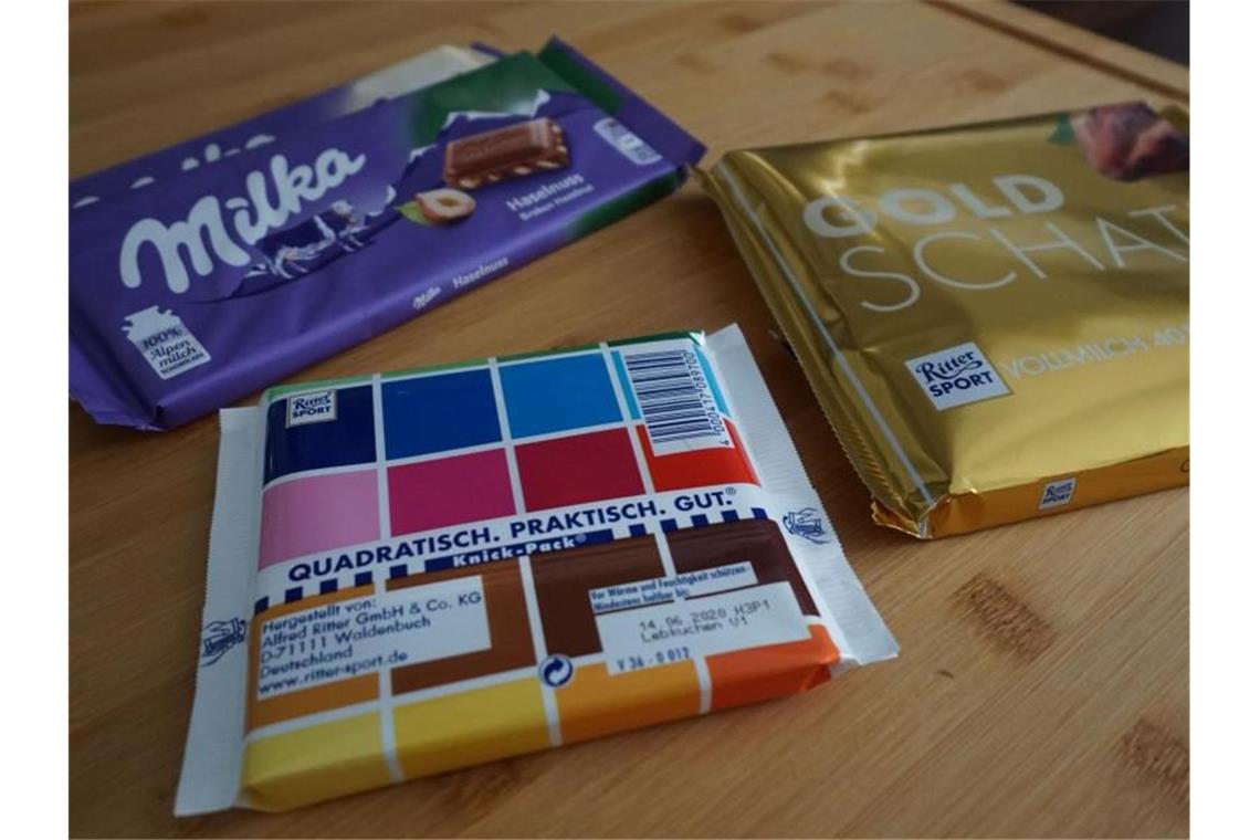 Schokoladentafeln der Marken Ritter Sport und Milka liegen auf einem Tisch. Foto: Alexander Blum/dpa/Symbolbild