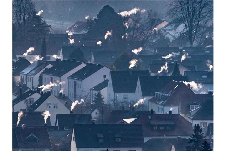 Schornsteine rauchen auf den Dächern der Häuser. Im Herbst sollen konkrete Maßnahmen und Gesetze für mehr Klimaschutz kommen. Foto: Armin Weigel/Archiv