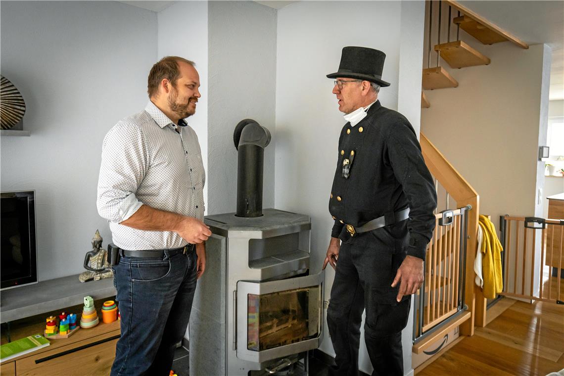 Schornsteinfeger Timo Hessel berät Danilo Heber. Dieser freut sich: Sein Kaminofen muss nicht ausgetauscht werden. Foto: Alexander Becher