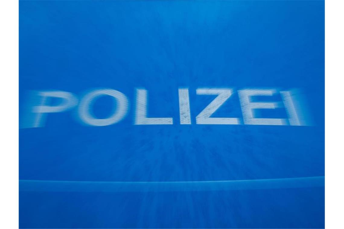 Betrunkener droht mit Hammer Schriftzug „Polizei“ auf der Motorhaube eines Funkstreifenwagens. Foto: Jens Büttner/Archivbild