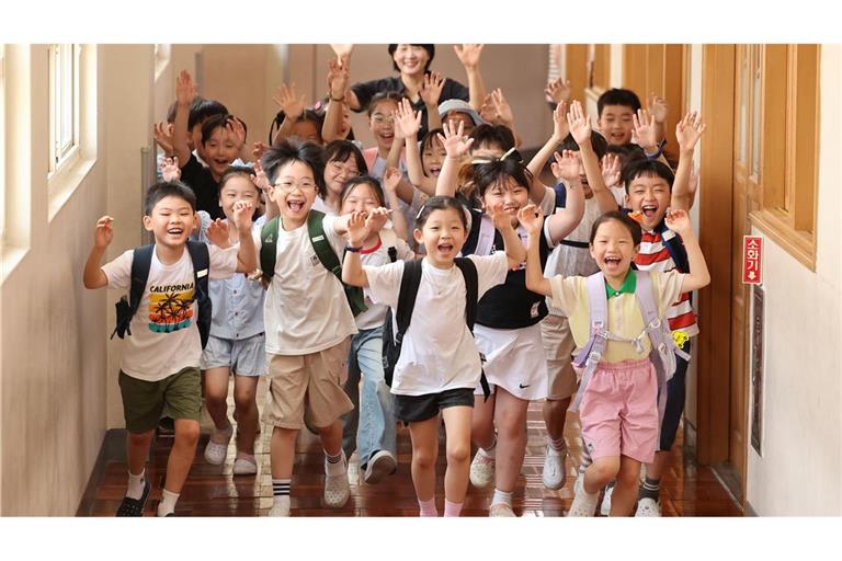 Schüler der Myeongryun-Grundschule in der südöstlichen Hafenstadt Busan eilen aus ihrem Klassenzimmer, nachdem sie in die Sommerferien entlassen wurden.
