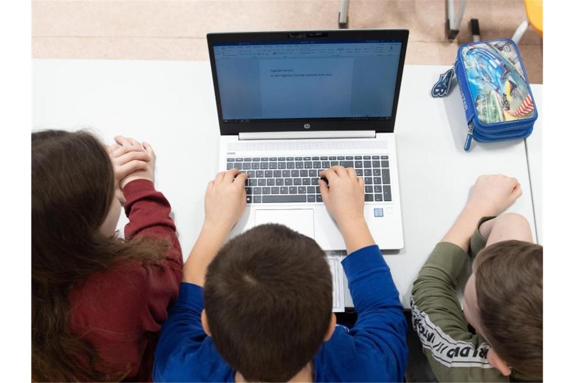 Schüler einer 3. Klasse sitzen während eines Presserundgangs in einem Klassenzimmer der Grundschule Georgius Agricola vor einem Laptop. Foto: Sebastian Kahnert/dpa-Zentralbild/dpa