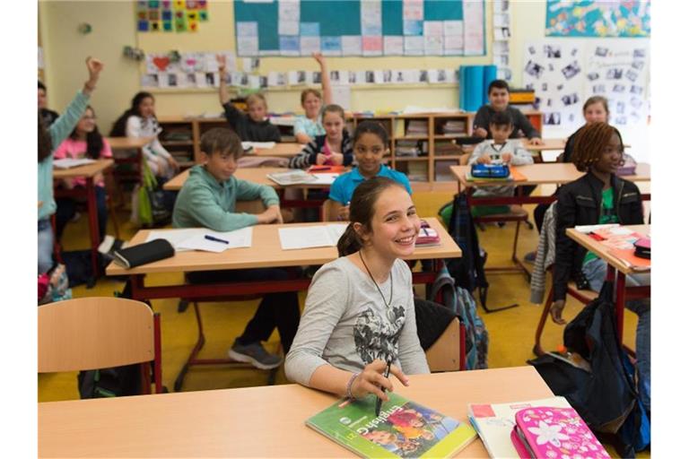 Schüler einer 5. Klasse sitzen in einer Gesamtschule. Foto: Marius Becker/dpa
