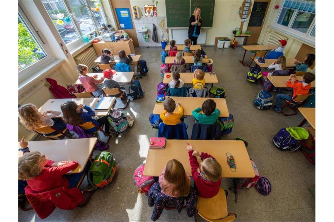 Schüler einer ersten Grundschulklasse sitzen im Unterricht auf ihren Plätzen. Foto: Robert Michael/dpa-Zentralbild/dpa