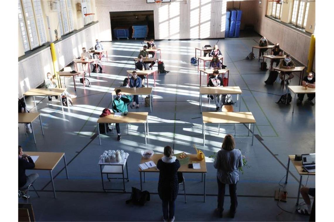 Auch Gymnasiallehrer sind gegen Absage von Abi-Prüfungen Schüler mit Mundschutz sitzen bei der Prüfungsvorbereitung fürs Abitur in einer Halle. Foto: Bodo Schackow/dpa-Zentralbild/dpa/Archivbild