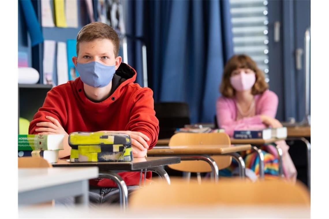Schüler und Schülerinnen eines Gymnasiums tragen Mundschutze. Foto: Sven Hoppe/dpa