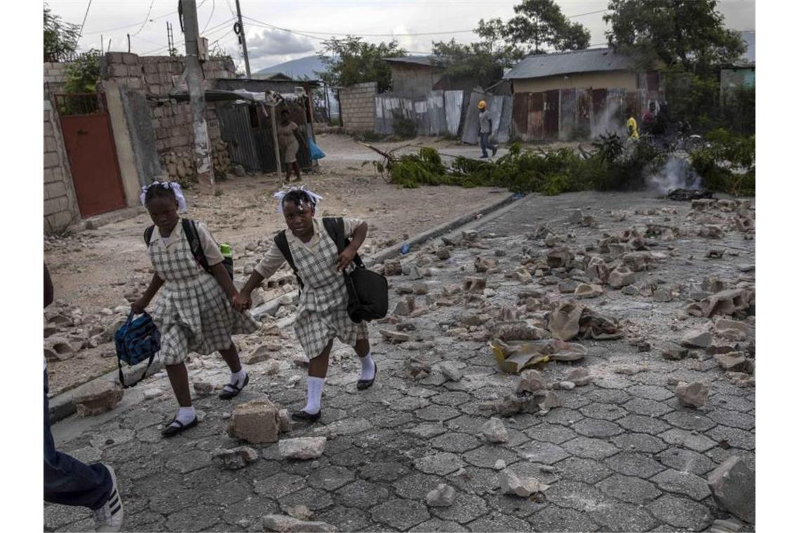 Haitianer an US-Grenze werden in „die Hölle“ zurückgeschickt Schülerinnen gehen Hand in Hand über eine Straße. Foto: Rodrigo Abd/AP/dpa