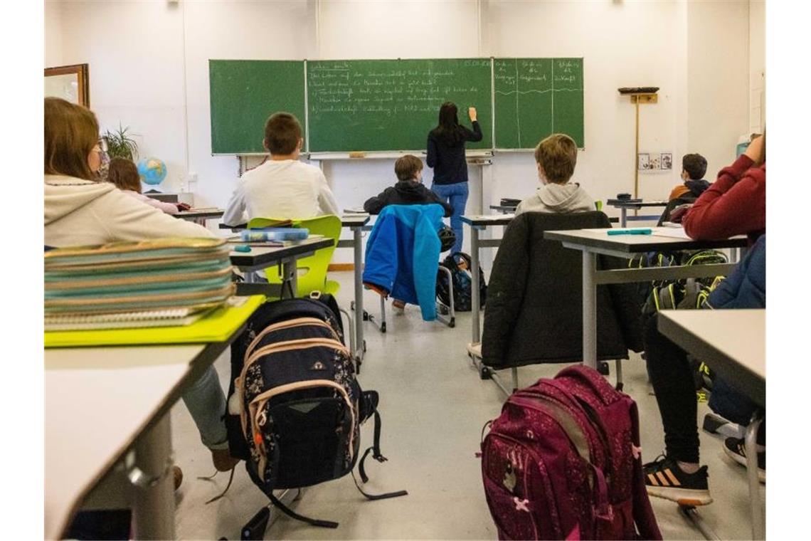 Schülerinnen und Schüler einer fünften Klasse sitzen während dem Unterricht in ihrem Klassenzimmer. Foto: Philipp von Ditfurth/dpa