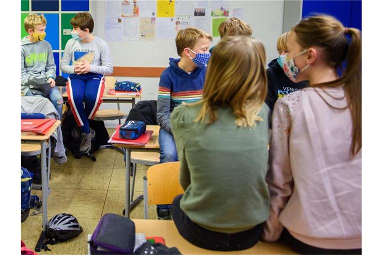 Schülerinnen und Schüler einer sechsten Klasse einer Schule in Kiel warten in ihrem Klassenzimmer auf den Unterrichtsbeginn. Foto: Gregor Fischer/dpa